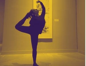 A dancer performs in a gallery in front of a print