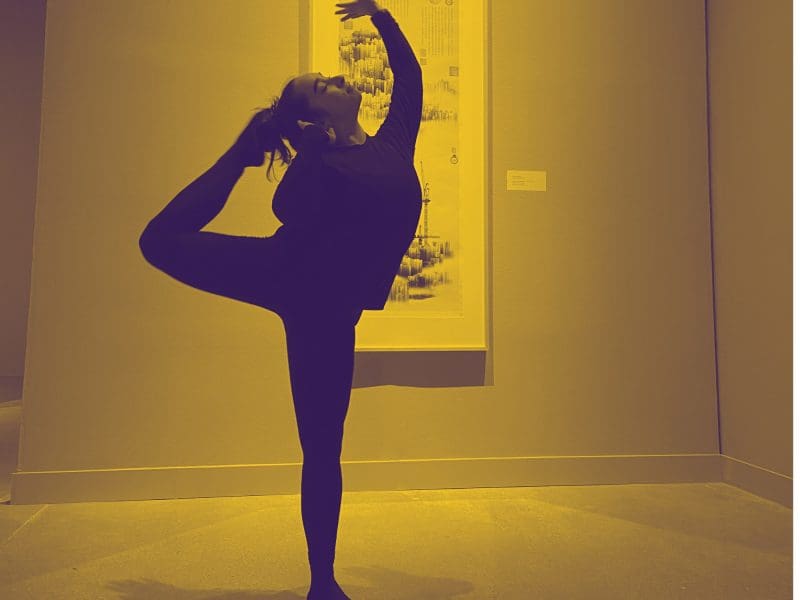 A dancer performs in a gallery in front of a print