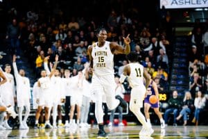 Quincy Ballard points at a teammate while running up the basketball court