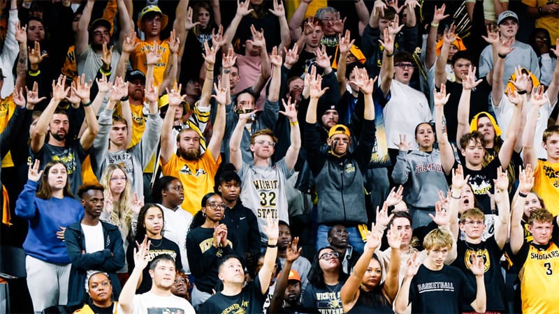 A large group of Wichita State students cheer in the student section at a game