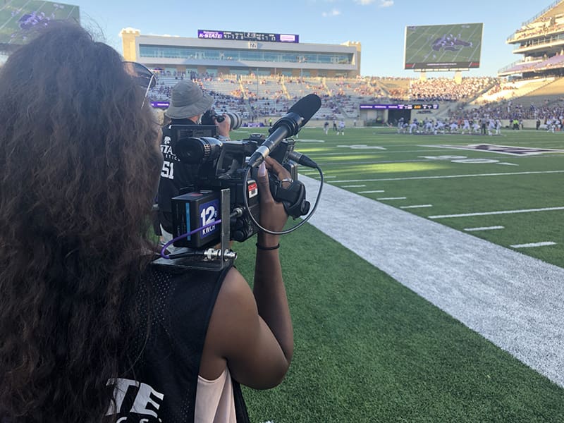 Daysha Bullocks mans a camera at a K-State football game.