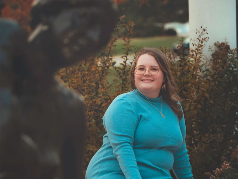 Lilith Samples next to the Mother and Child statue by Charles Grafly on campus