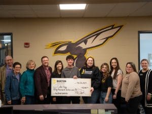 Luke Hoy poses with members of the Barton School holding his $50,000 ceremonial check