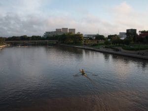A member of the Shocker rowing team rows across the Arkansas River