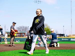 A young girl happily collects candy-filled eggs on the field at Eck Stadium