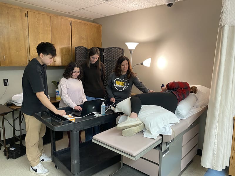 Anna Brake works with other Wichita State students to collect ECG data during a research session aimed at extracting fetal heart signals from maternal ECG and ambient bodily noise.