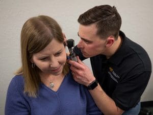 Audiologist performing a hearing exam on a patient