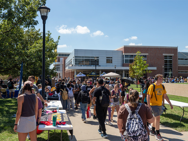 Students on campus at an event in front of the Rhatigan Student Center.