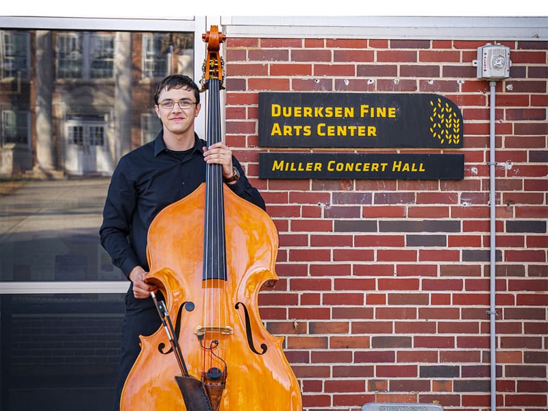 John Mark Koontz stands outside Miller Concert Hall with his double bass