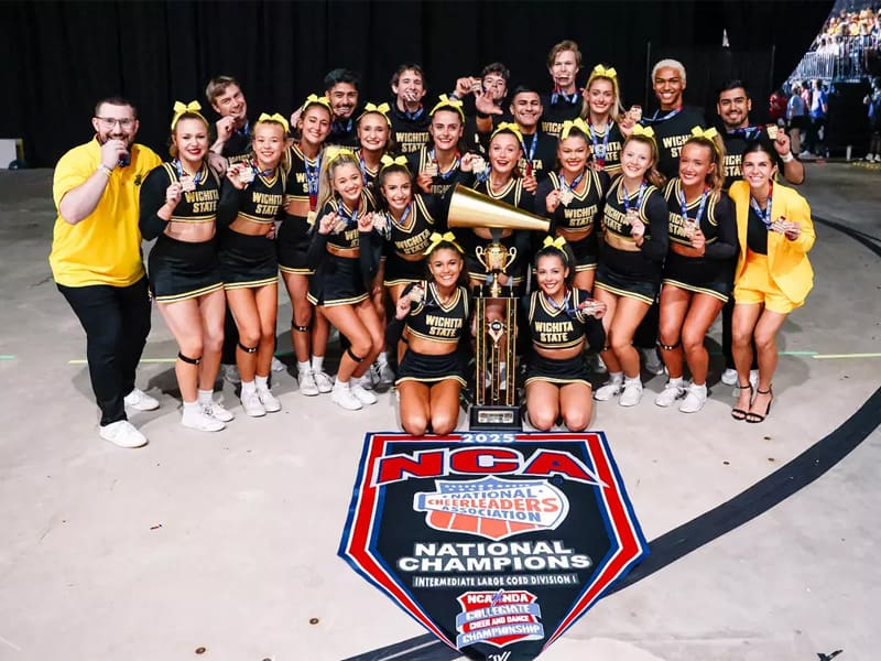 The Shocker cheer team posing with their trophy after finishing first in the NCA nationals.