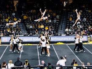 Shocker cheer members are thrown into the air during a routine in Charles Koch Arena