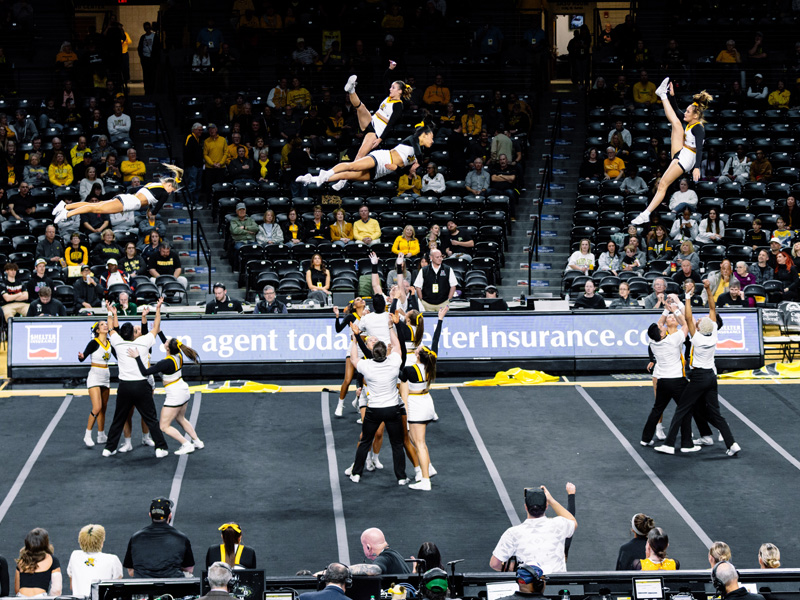 Shocker cheer members are thrown into the air during a routine in Charles Koch Arena