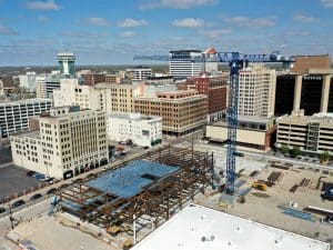 A drone shot featuring the Wichita Biomedical Campus construction crane with the Wichita downtown area sprawling in the background