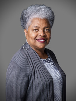 Deltha Colvin poses in front of a gray background