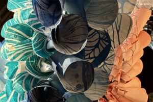 An artwork by artist Abhidnya Ghuge, created from woodblock-printed, rolled paper plates.