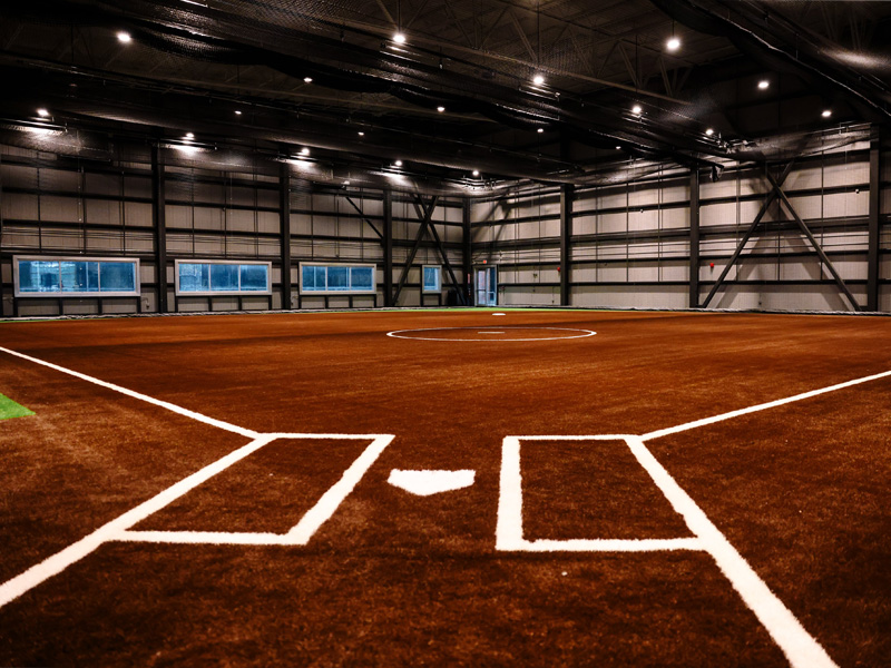 A view of the new indoor practice facility at Wilkins Stadium from behind the batter's plate, showing an indoor softball diamond