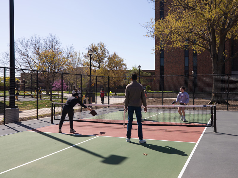 Students playing pickleball on the campus courts