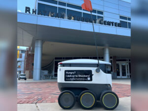 A Starship delivery robot on a delivery in front of the Rhatigan Student Center