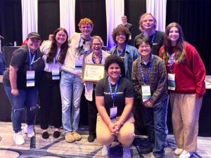 Student journalists from The Sunflower pose at the National College Media Convention after being awarded the Pacemaker award