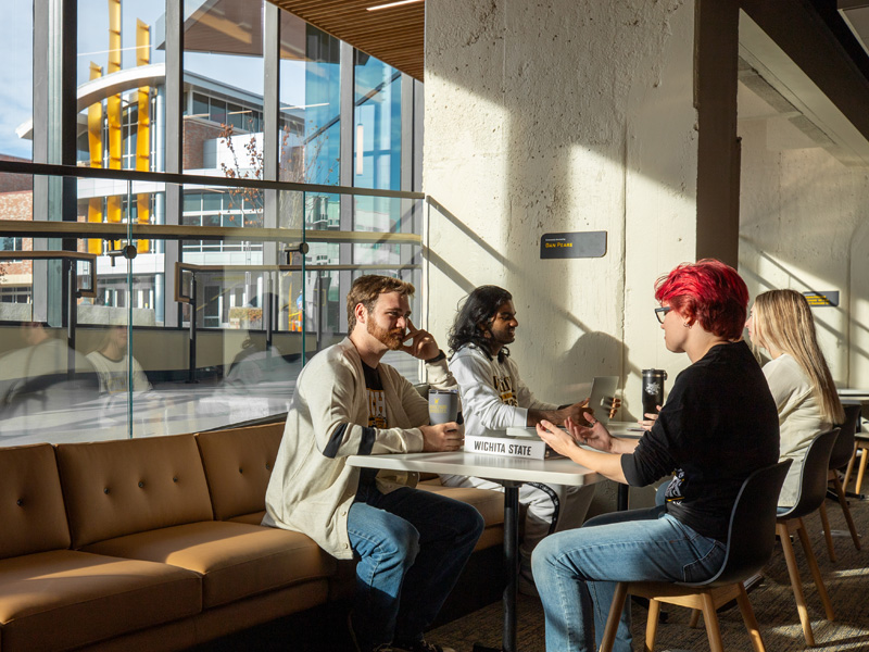 Students study in the Shocker Success Center with the Rhatigan Student Center in the background