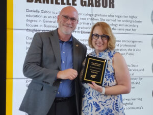 David Miller is handed his 2025 Alumni of the Year award