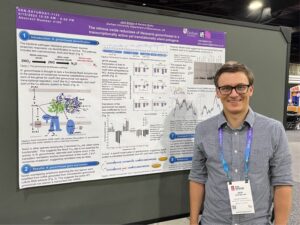 Photograph of Dr. Jack Bolton standing next to a scientific poster.