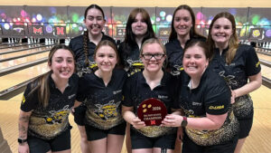 The Shocker women's bowling team holds up the winning Big Red Invite trophy