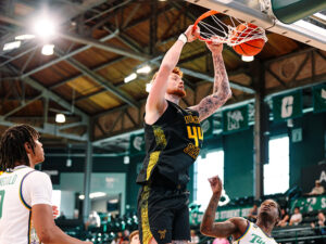 Men's basketball center, Will Berg, dunks a ball against Tulane