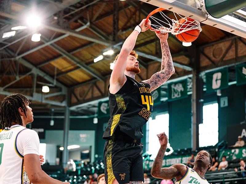 Men's basketball center, Will Berg, dunks a ball against Tulane