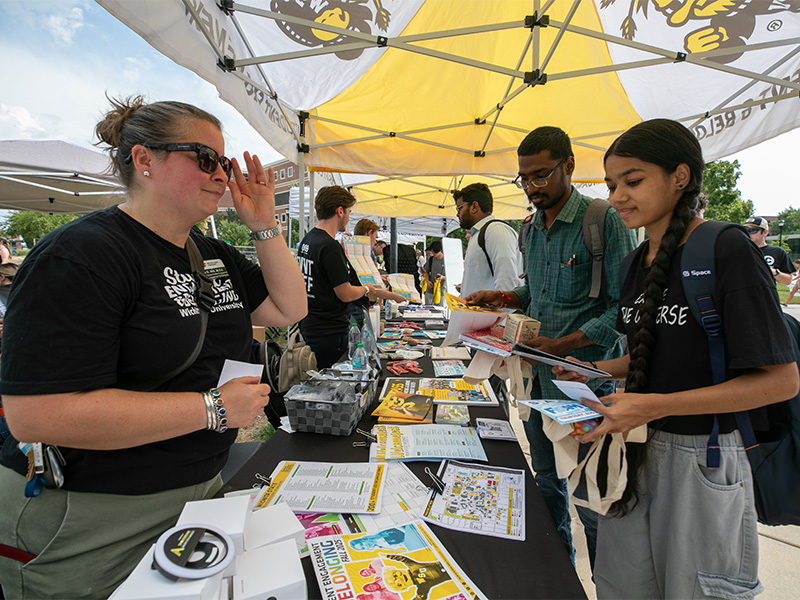 A student visits a table with information on Wichita State during the first day of school