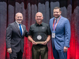 John Tomblin holds his Lifetime Achievement Award with representatives from MILAM