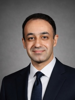Headshot of Dr. Mostafa Hassanalian in a black suit and tie on a gray background