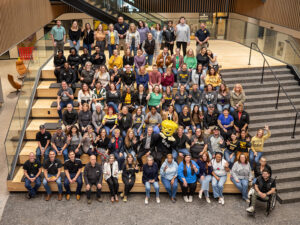 Employees pose at the stairs in Woolsey Hall