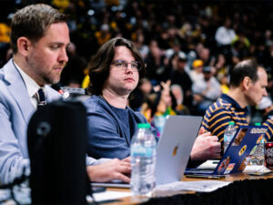 Owen Prothro sits at the press table in Charles Koch Arena during a men's basketball game