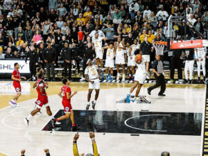 A Shocker jumps to dunk while the crowd cheers in the background and foreground