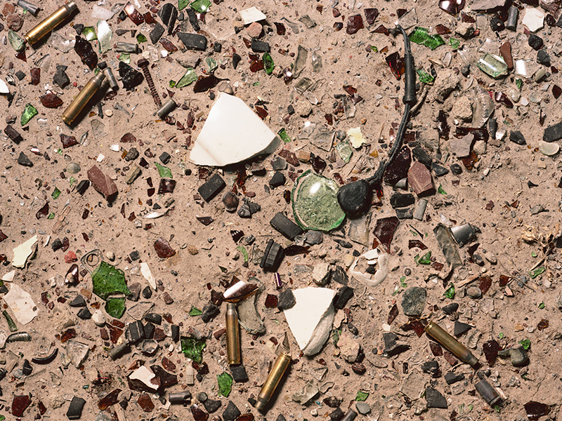 A photo collage of broken glass, bullets, and cigarette butts