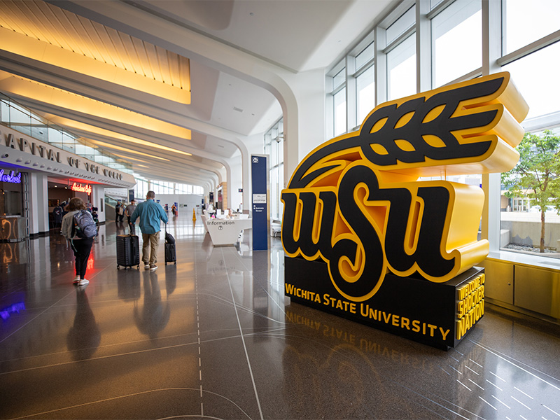 The WSU wheat kernel sculpture sits in the Dwight D. Eisenhower National Airport terminal with Wichita State University and Welcome to Shocker Nation on the base