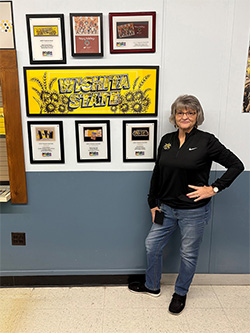 Ellen Abbey standing outside of Shocker Printing with awards.