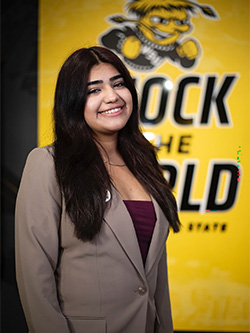 Dulce Torres Gonzalez in front of a "Shock the World" WSU sign