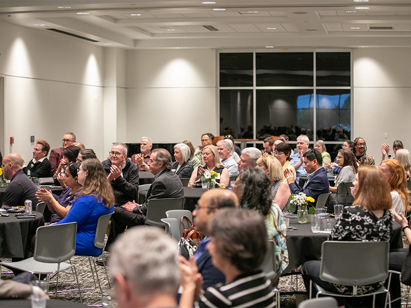 Faculty members clap at the Tenure and Promotion Awards celebration