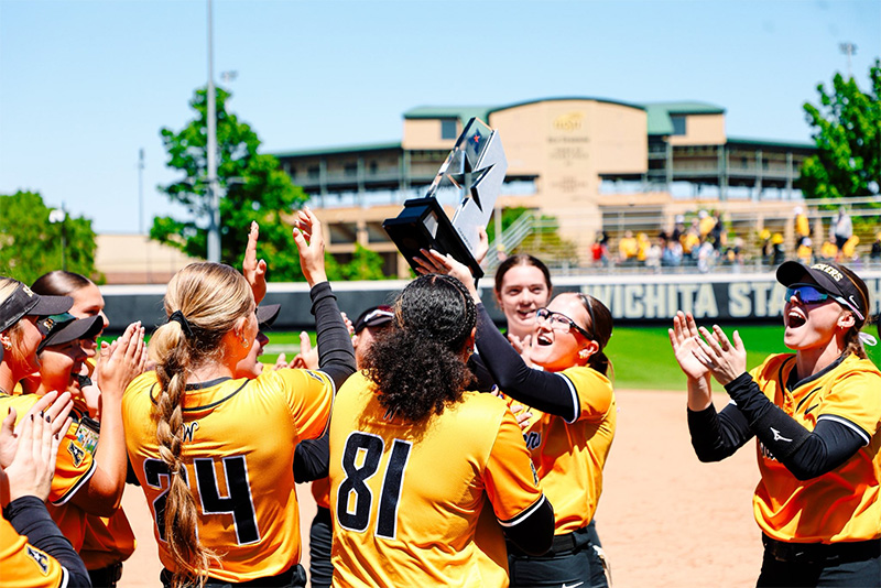 The Shocker softball team celebrates winning a share of the American Conference title by holding their trophy