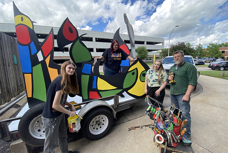 Young people work on a parade entry.