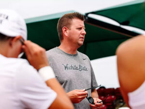 Jacob Eddins talks with members of the Shocker women's tennis team