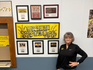 Ellen Abbey standing outside of Shocker Printing with awards.