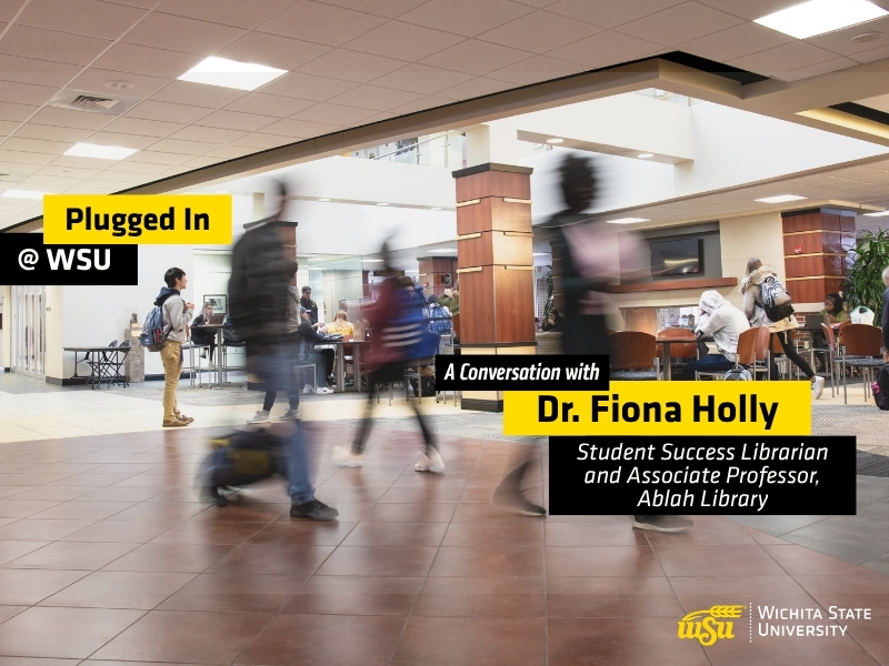 Students walk through a busy indoor campus commons area at Wichita State University. Several people are shown moving across the foreground with motion blur, while others sit and study at tables in the background. Overlay text reads "Plugged In @ WSU" and "A Conversation with Dr. Fiona Holly, Student Success Librarian and Assistant Professor, Ablah Library." The Wichita State University logo appears in the lower-right corner. The image promotes a podcast episode featuring WSU Success Coaches and highlights student activity and engagement on campus.