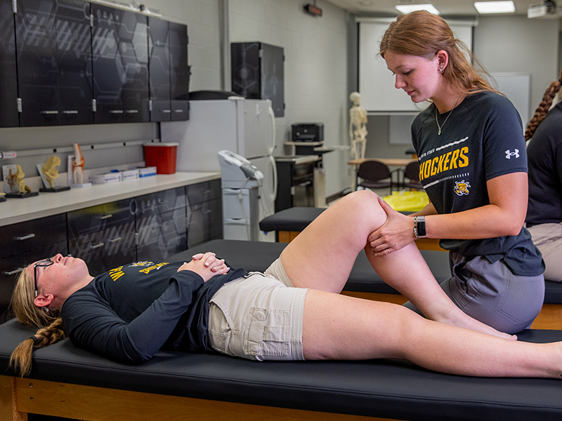 Athletic Training student examining a patient's knee