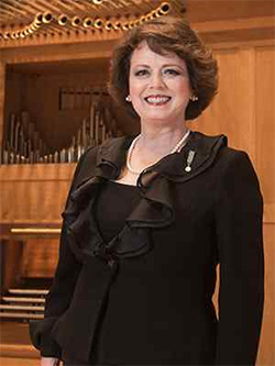 Lynne Davis stands in front of an organ